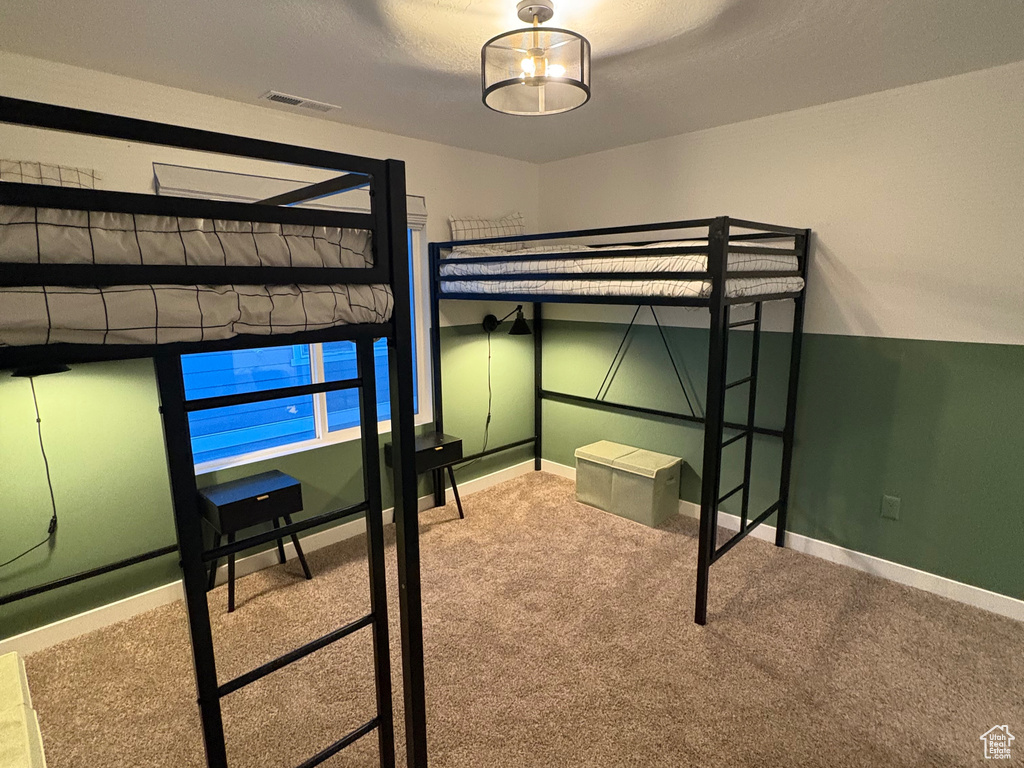 Unfurnished bedroom featuring a textured ceiling, carpet flooring, and baseboards