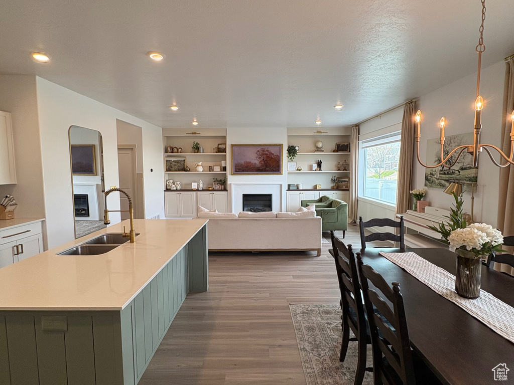 Dining room featuring a fireplace, a chandelier, dark wood-type flooring, and recessed lighting