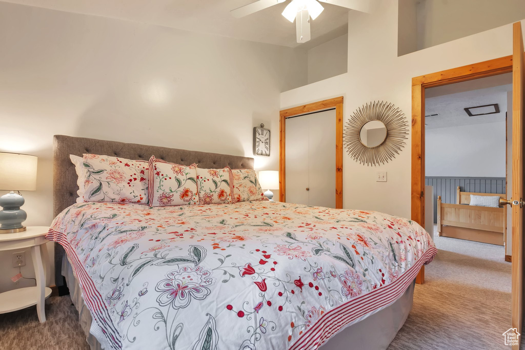 Carpeted bedroom featuring lofted ceiling and ceiling fan