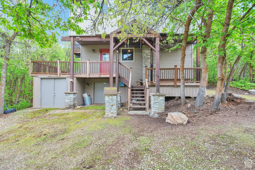 Rear view of house with stairs and a wooden deck