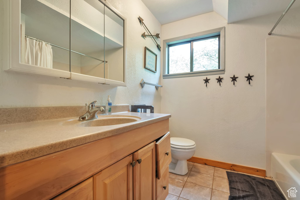 Bathroom featuring curtained shower, tile patterned floors, toilet, and vanity