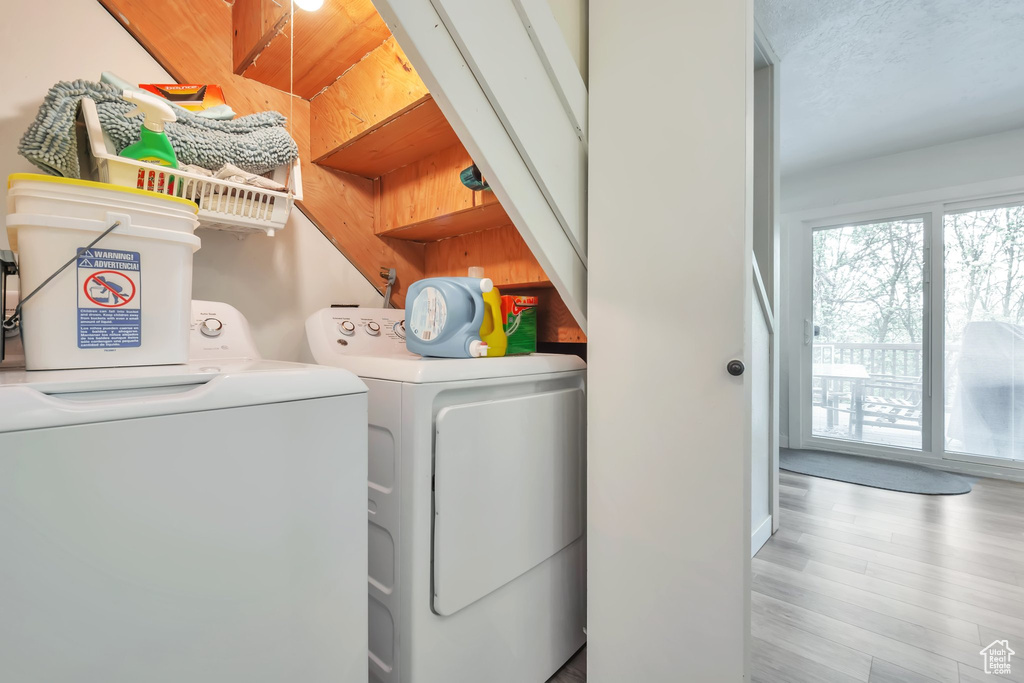Laundry area featuring independent washer and dryer and light wood-type flooring