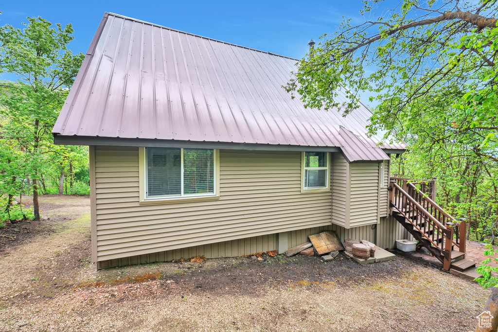 View of side of home with metal roof and stairs