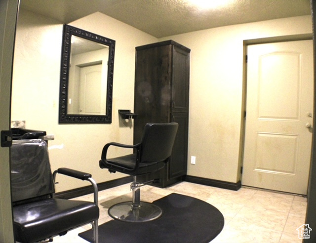 Office space with a textured ceiling and baseboards