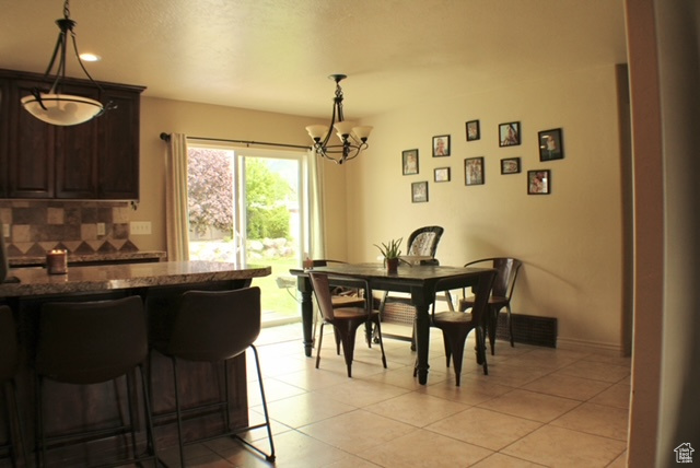 Dining room with a chandelier, light tile patterned flooring, and recessed lighting