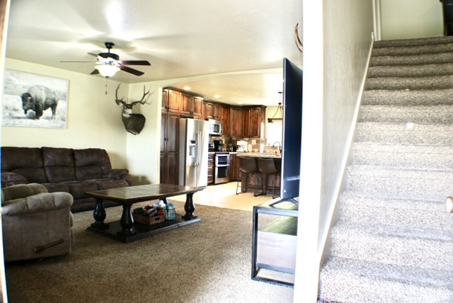 Living area featuring stairs and a ceiling fan