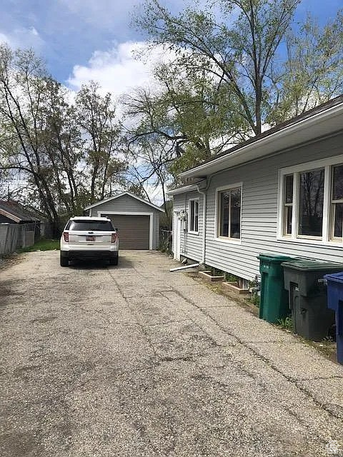 View of property exterior featuring a detached garage and an outbuilding