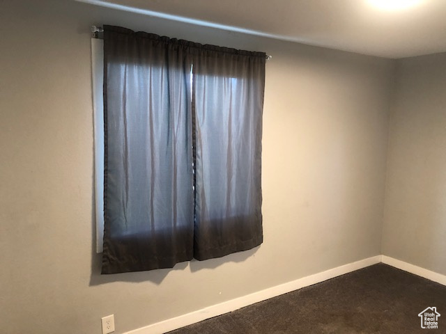 Carpeted empty room featuring baseboards