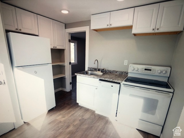 Kitchen with white appliances, a sink, light wood-style flooring, and white cabinetry