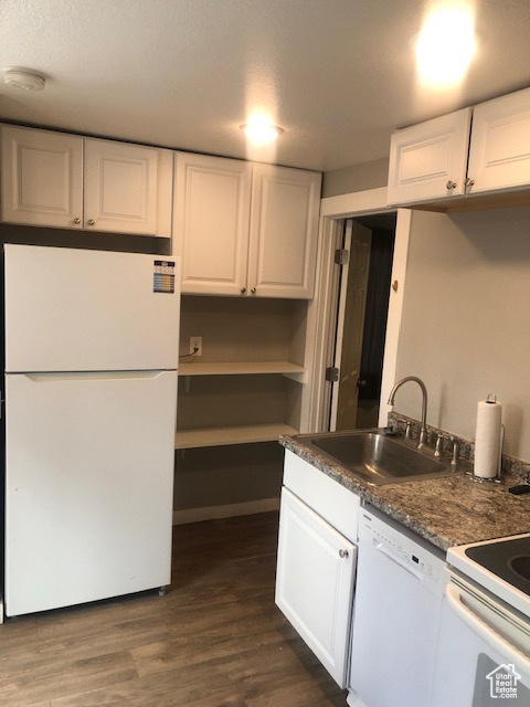 Kitchen featuring white appliances, a sink, white cabinets, and dark wood finished floors