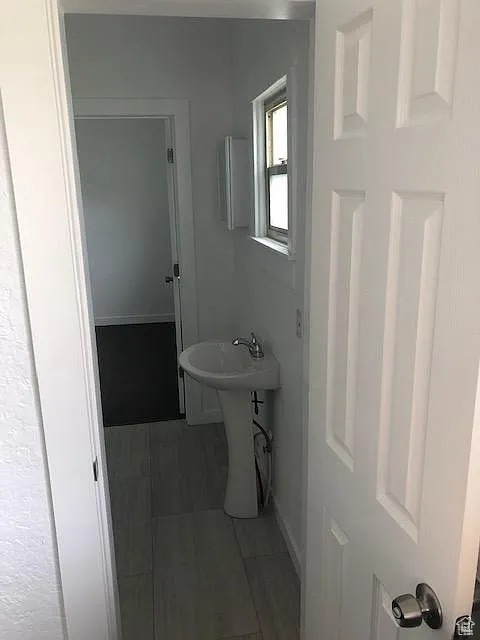 Bathroom with tile patterned floors, baseboards, and a sink