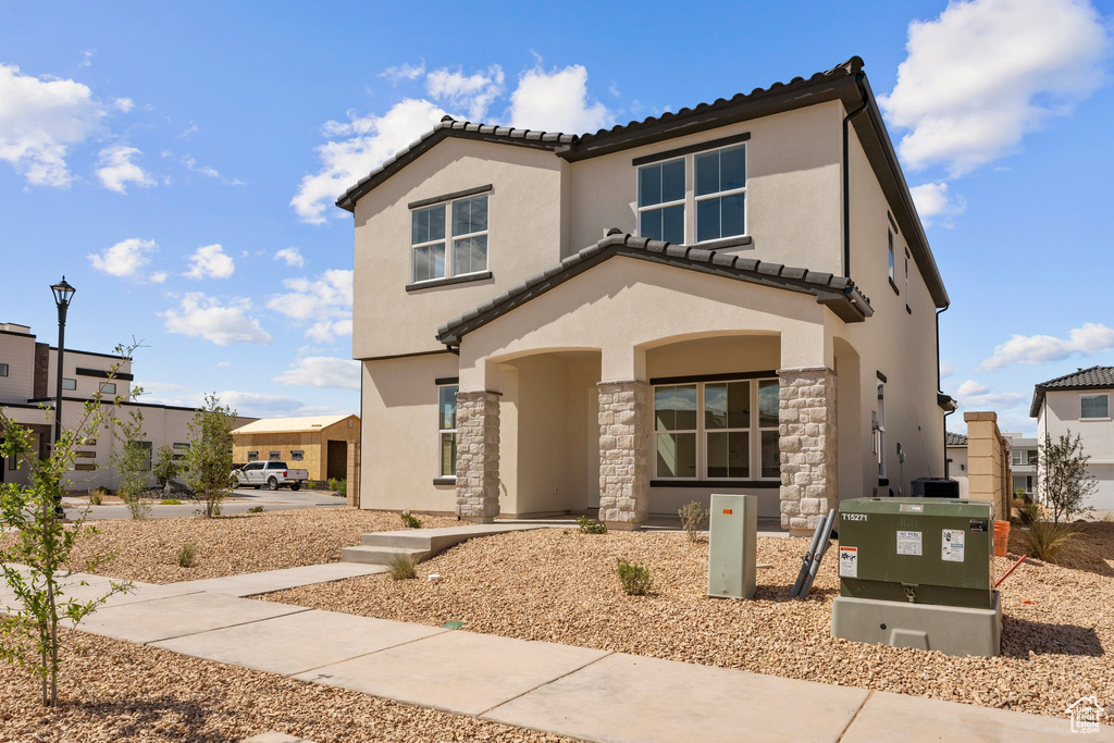 View of front of house featuring stone siding, a tile roof, stucco siding, and a residential view