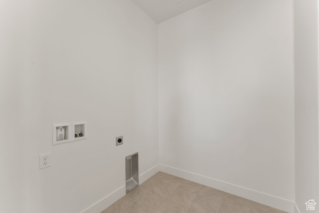 Clothes washing area featuring electric dryer hookup, hookup for a washing machine, baseboards, and light tile patterned floors