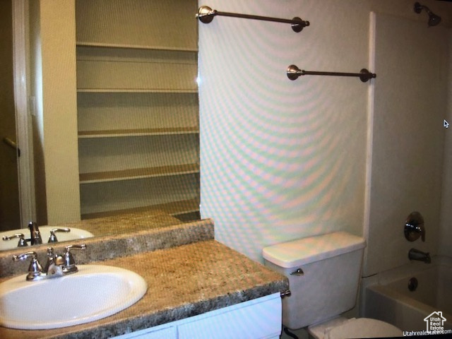 Full bathroom featuring vanity, toilet, and  shower combination