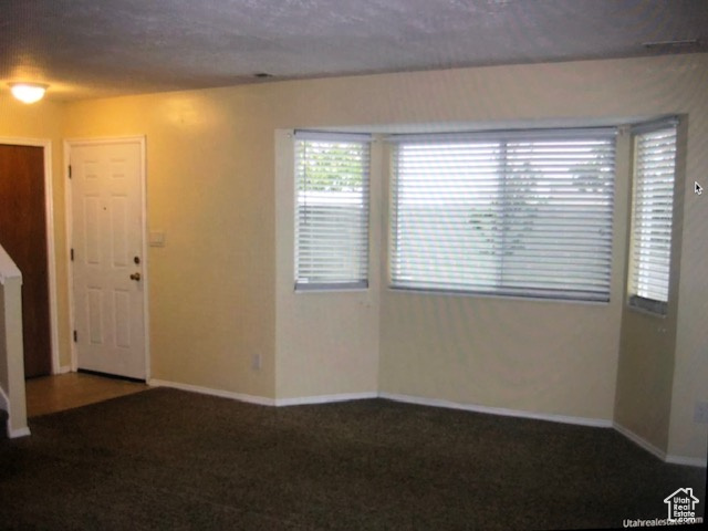 Empty room featuring carpet and baseboards