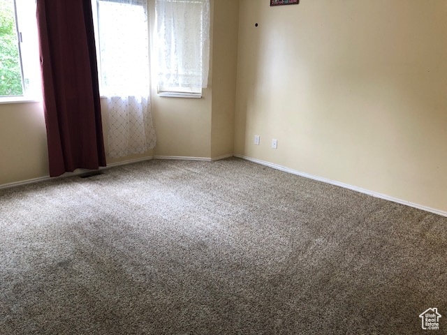 Carpeted empty room featuring baseboards