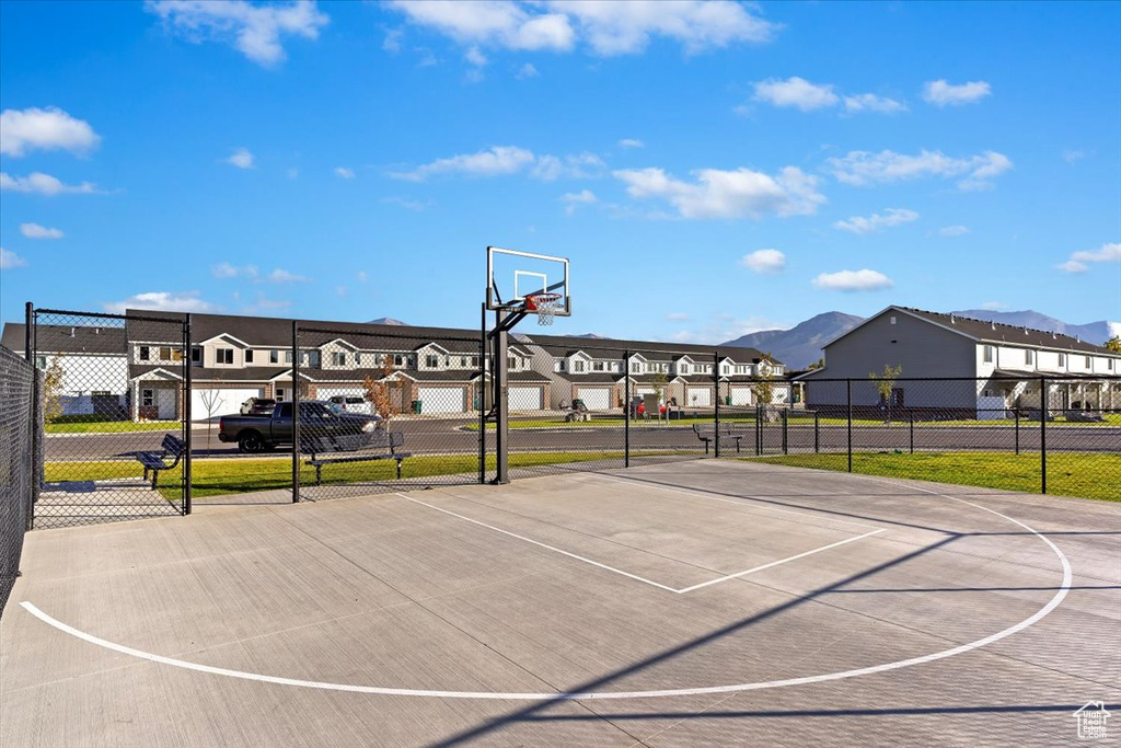 View of basketball court with a residential view, community basketball court, fence, and a mountain view