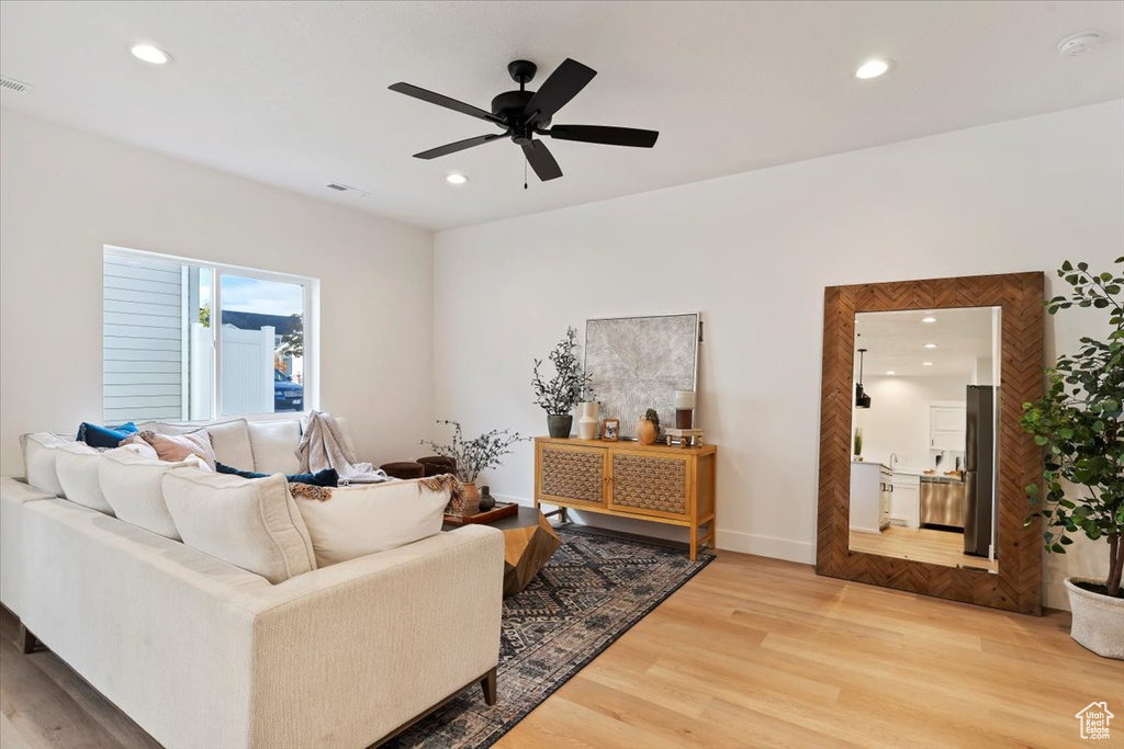 Living room featuring light wood-style floors, ceiling fan, and recessed lighting