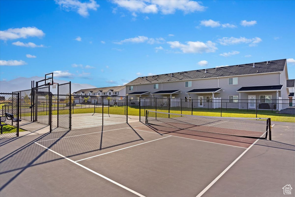View of basketball court with a residential view, fence, and a tennis court