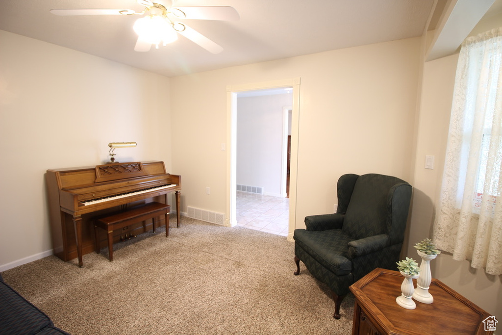 Sitting room with ceiling fan, carpet flooring, and baseboards