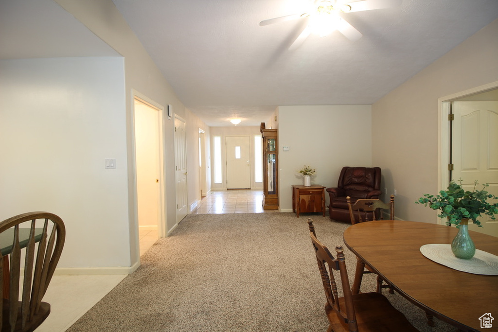 Dining area with ceiling fan, light carpet, and baseboards