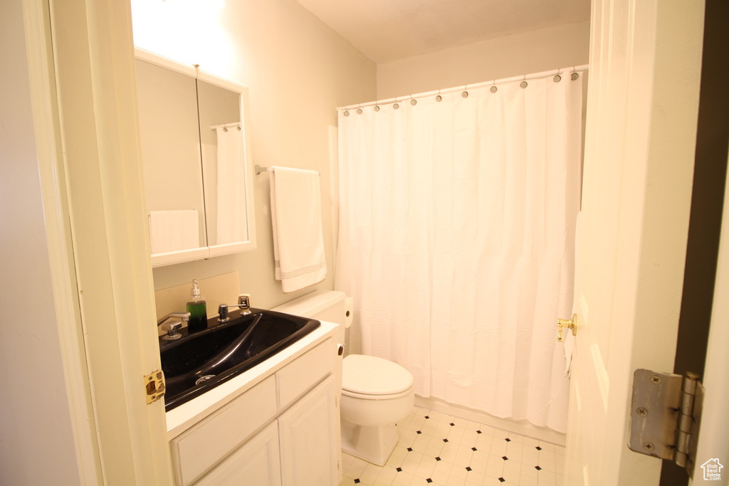 Bathroom featuring toilet, vanity, and tile patterned floors