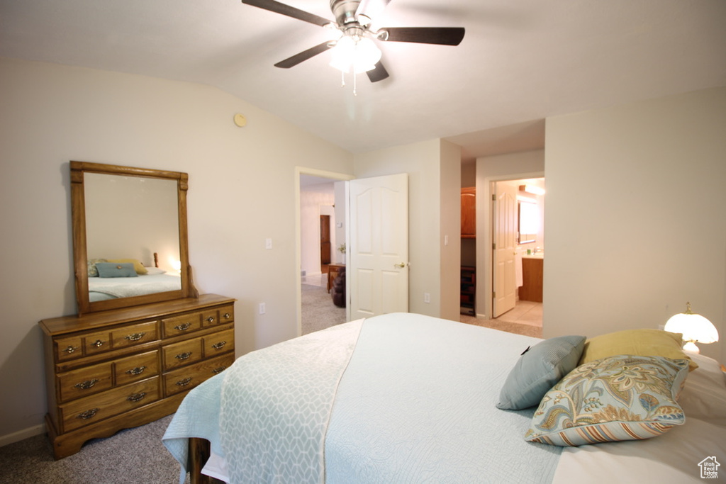 Bedroom featuring carpet flooring, vaulted ceiling, baseboards, a ceiling fan, and ensuite bath