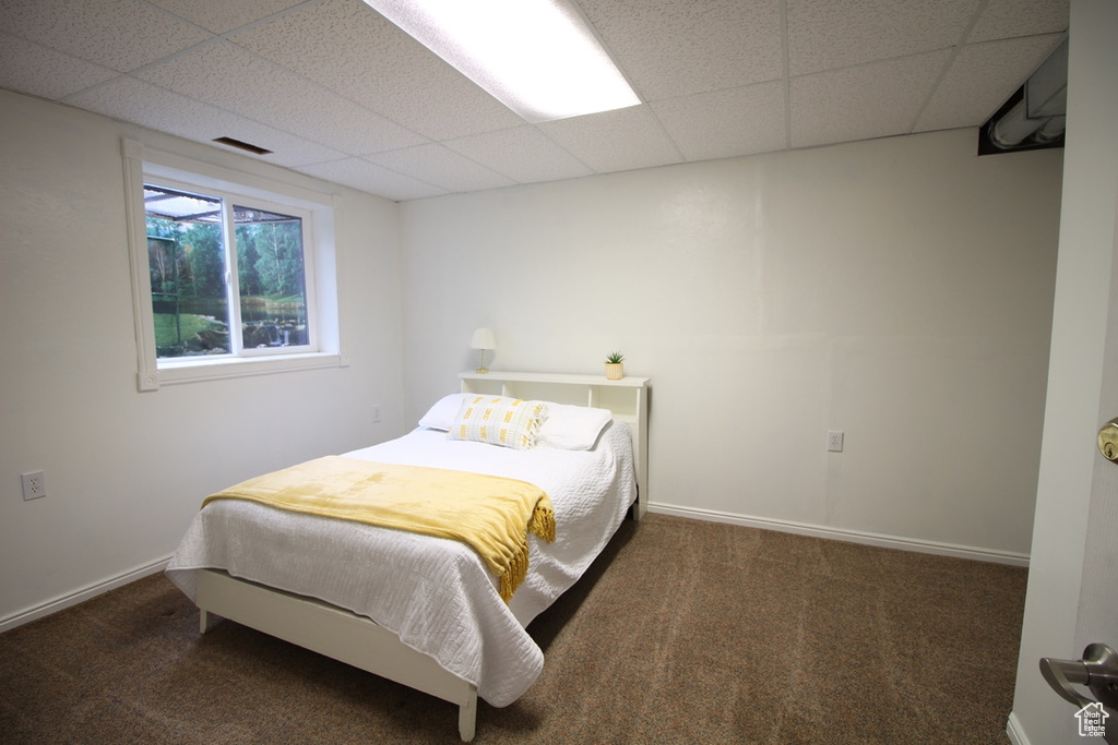Bedroom featuring a drop ceiling and carpet floors