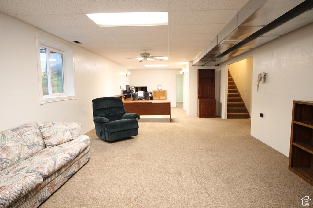 Carpeted living area featuring an office area, stairs, and a paneled ceiling