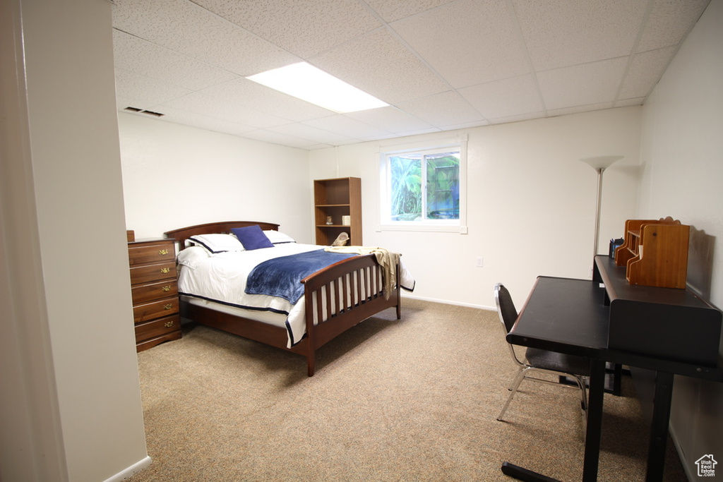 Bedroom featuring carpet, a paneled ceiling, and baseboards