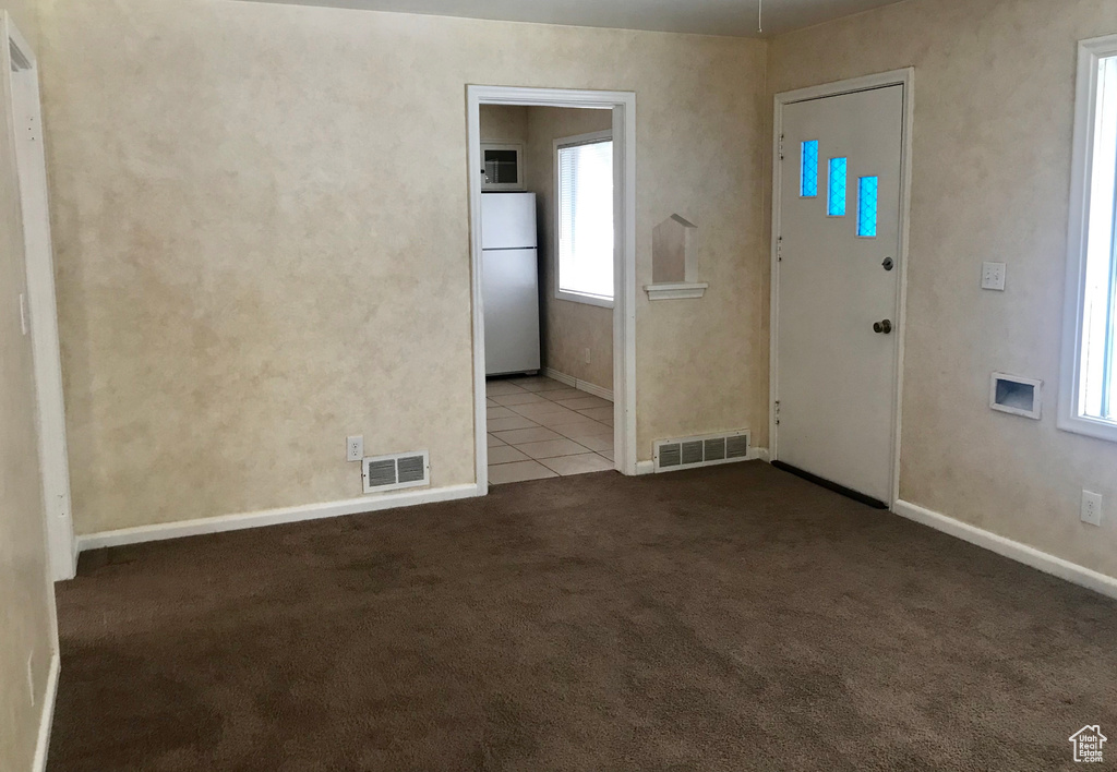 Unfurnished room with carpet, plenty of natural light, and baseboards