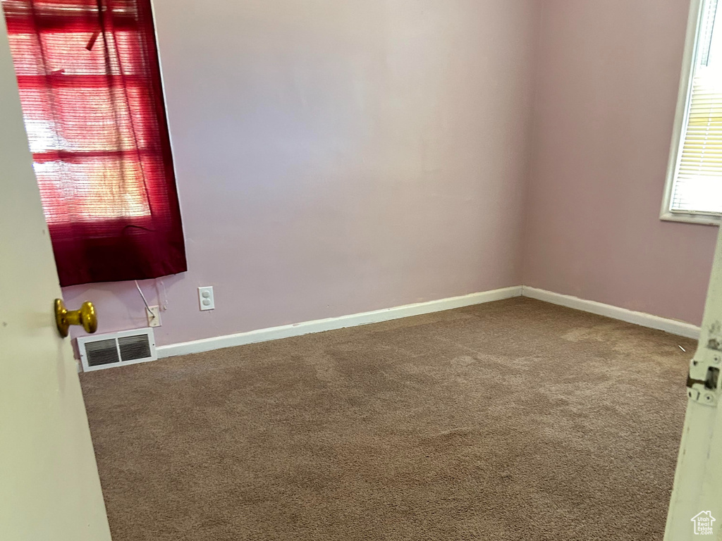 Unfurnished room featuring carpet and baseboards