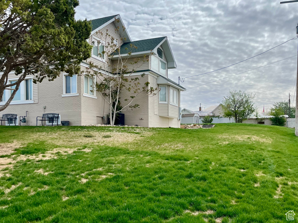 Rear view of property with a lawn and brick siding