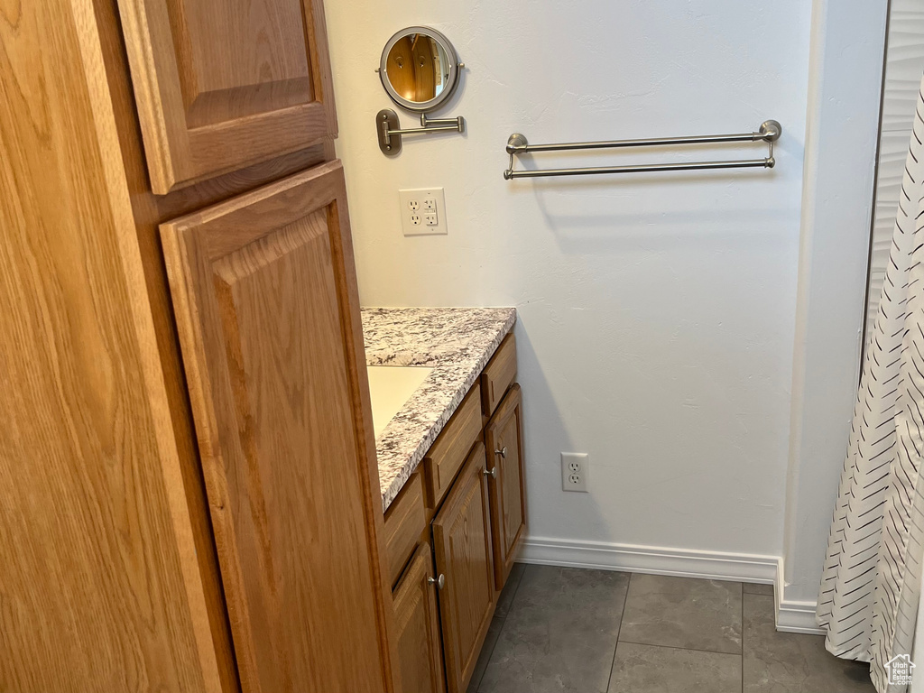Bathroom with tile patterned flooring, baseboards, and vanity