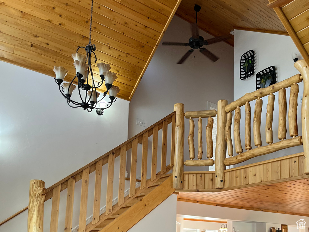Stairway with wood ceiling, vaulted ceiling, a ceiling fan, and a chandelier