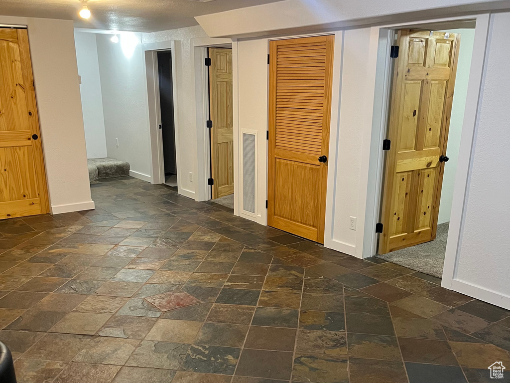 Finished basement featuring stone tile flooring and baseboards