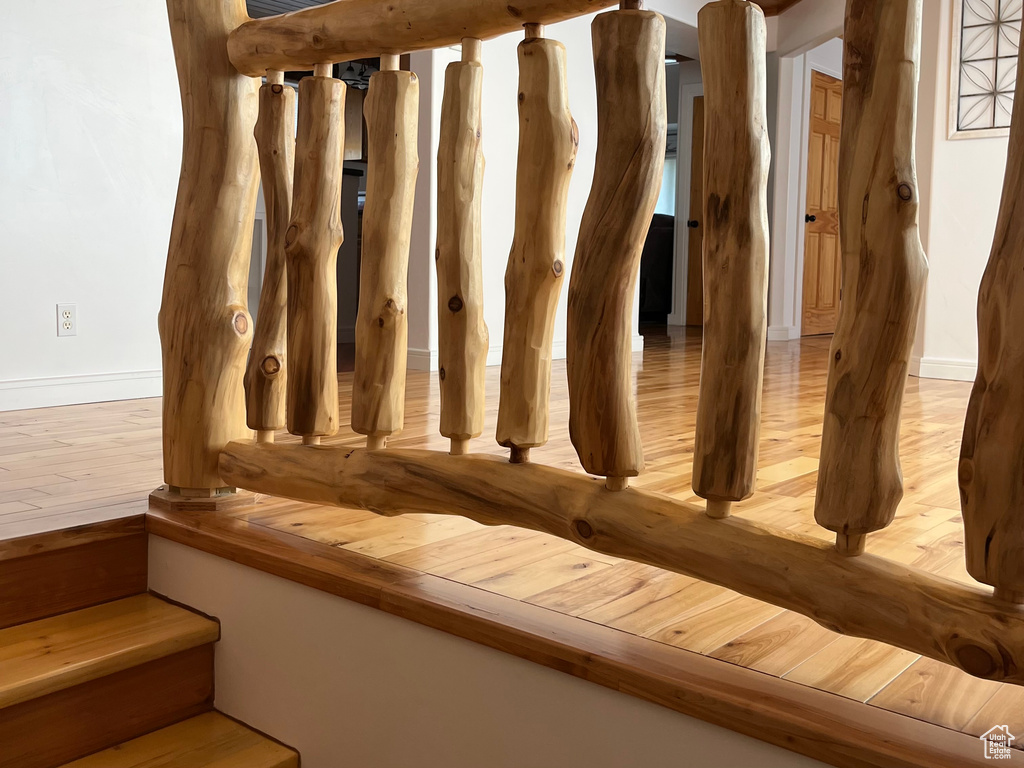 Stairs with wood finished floors and baseboards