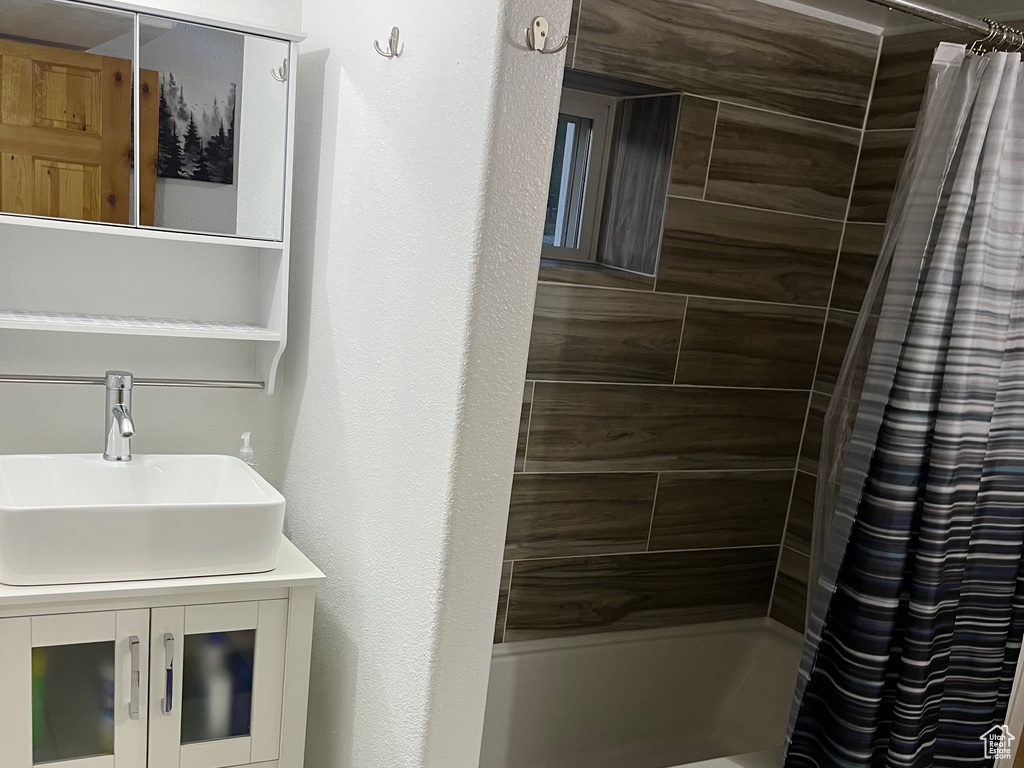 Full bathroom featuring shower / bath combination with curtain and vanity