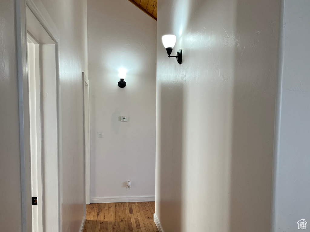 Corridor with light wood-style floors and baseboards