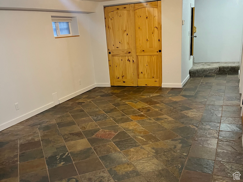 Below grade area with stone tile floors and baseboards