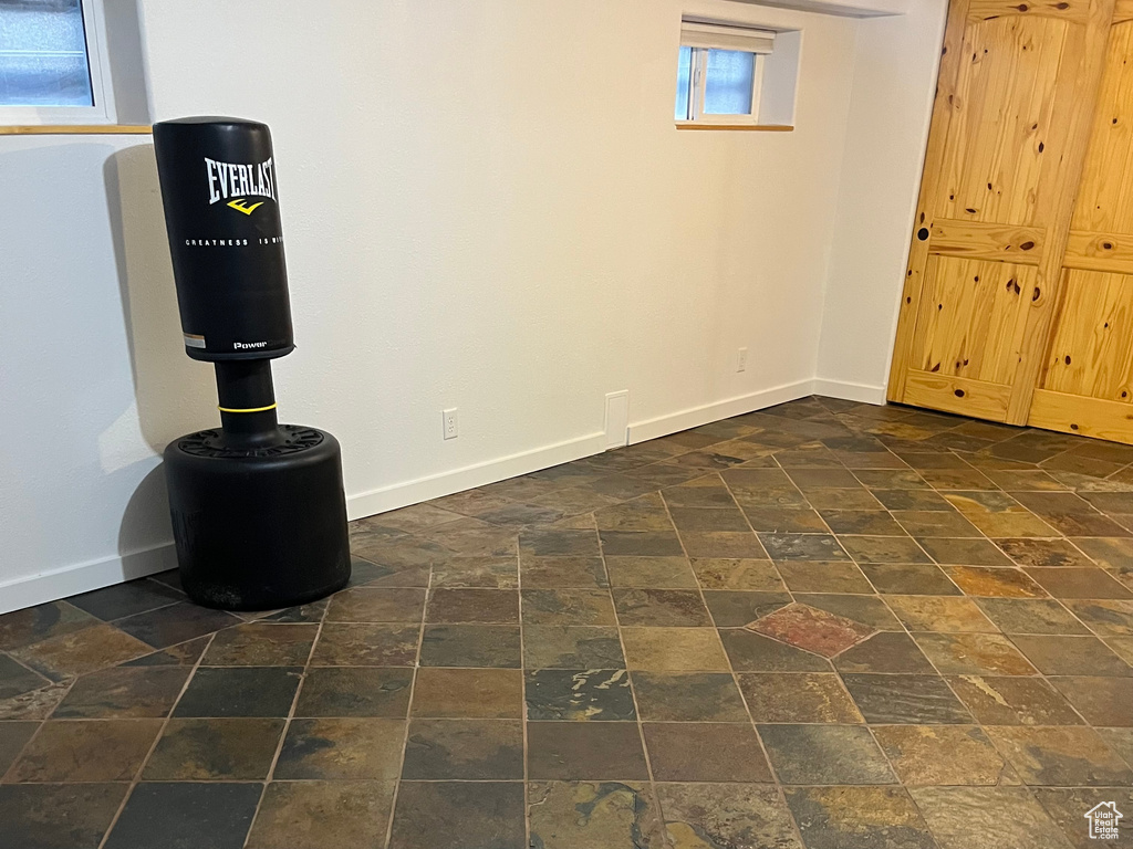 Below grade area featuring baseboards and dark stone finish flooring