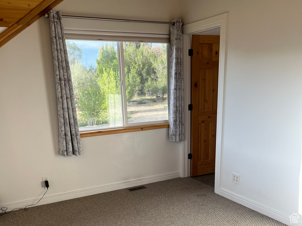 Carpeted empty room featuring baseboards