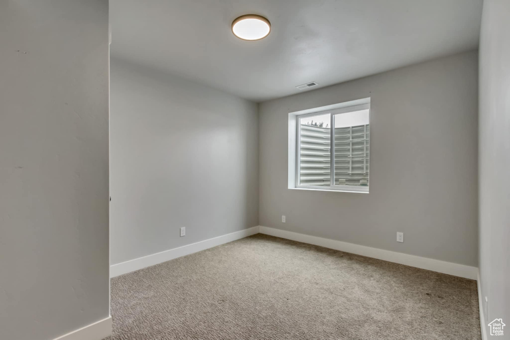 Spare room with carpet and baseboards