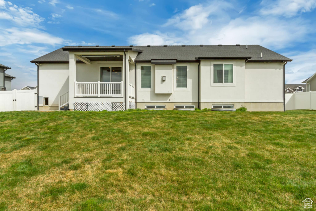 Back of house featuring stucco siding and a gate