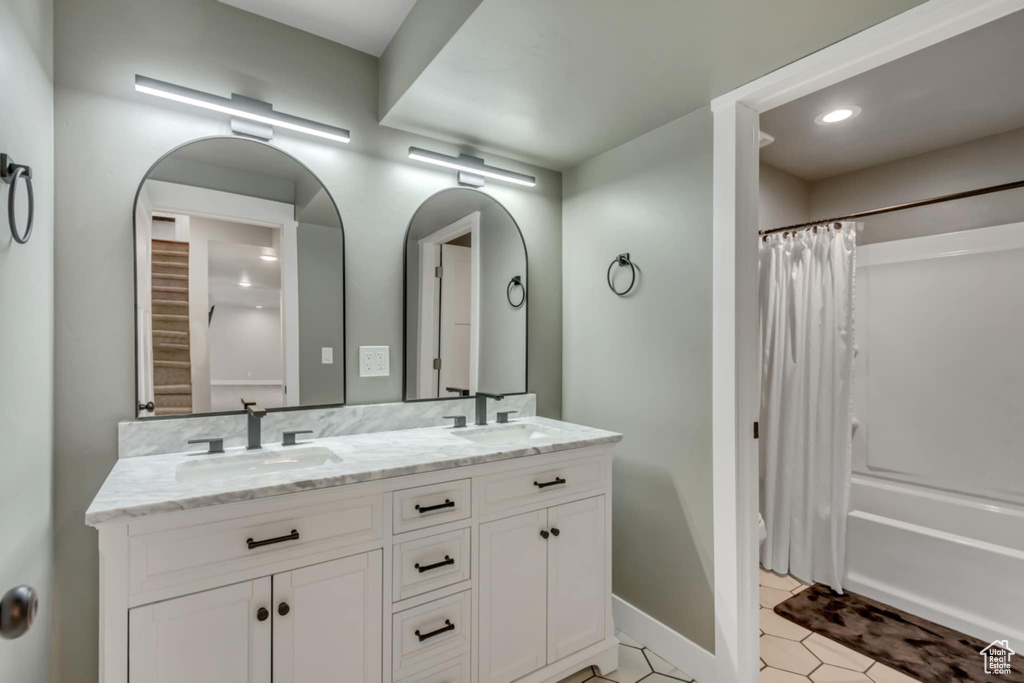 Bathroom with double vanity, shower / tub combo with curtain, tile patterned floors, baseboards, and recessed lighting