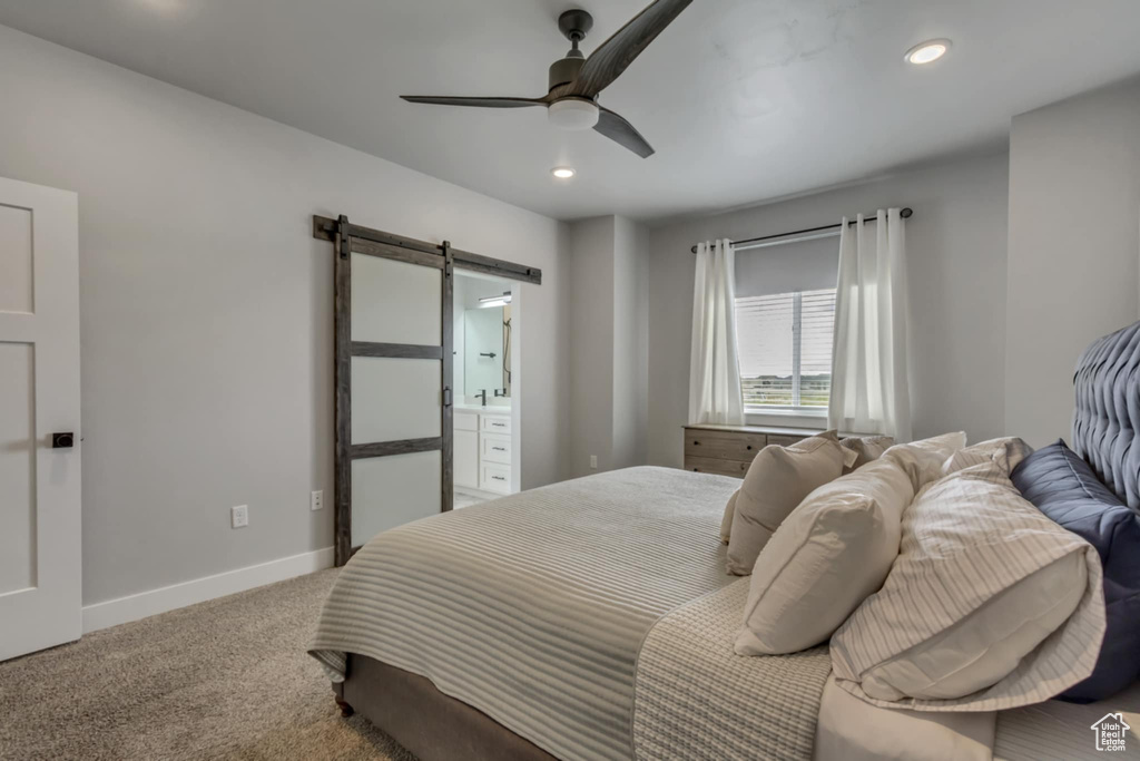 Carpeted bedroom featuring a barn door, baseboards, recessed lighting, a ceiling fan, and connected bathroom
