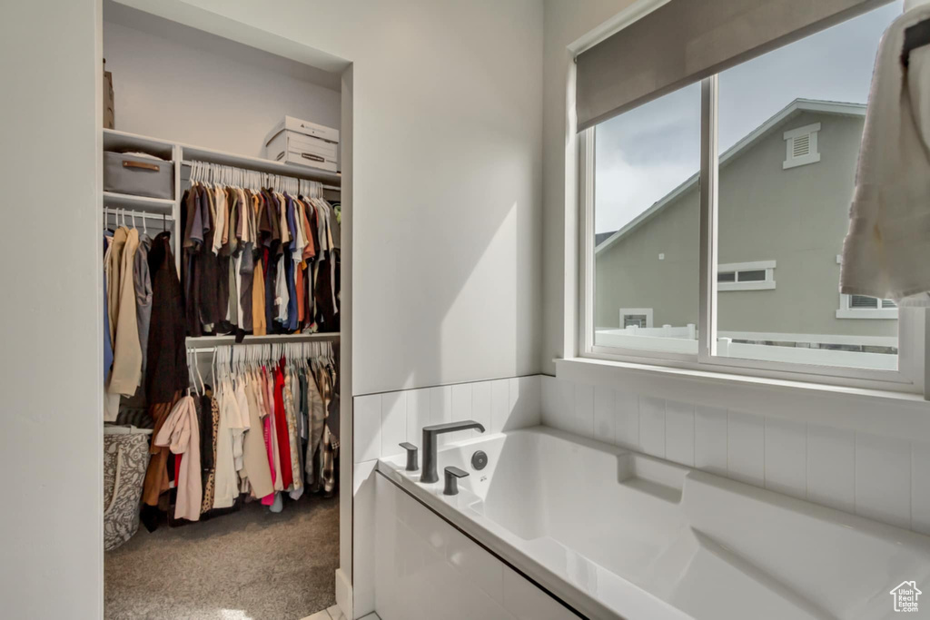 Full bath featuring a bath, plenty of natural light, and a walk in closet