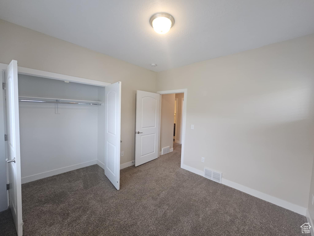 Unfurnished bedroom featuring carpet flooring, a closet, and baseboards