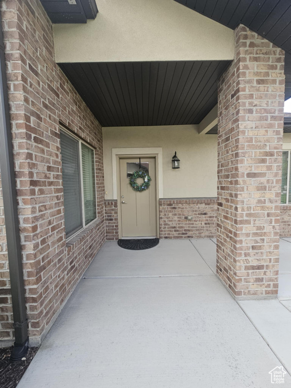 Entrance to property with stucco siding and brick siding