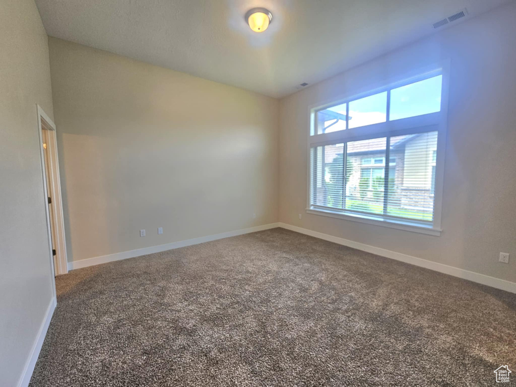 Carpeted empty room with baseboards